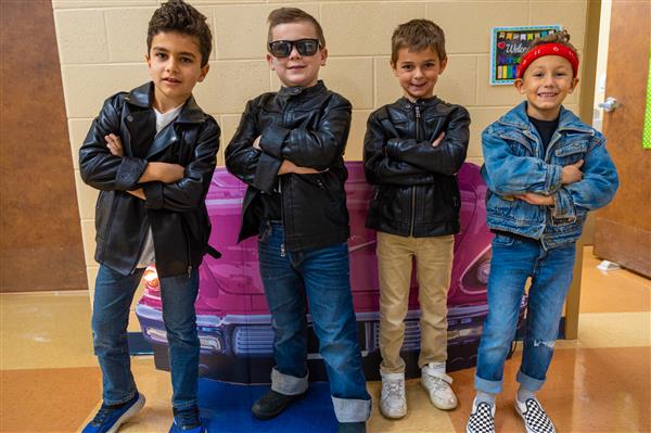 four boys in jackets with their arms crossed